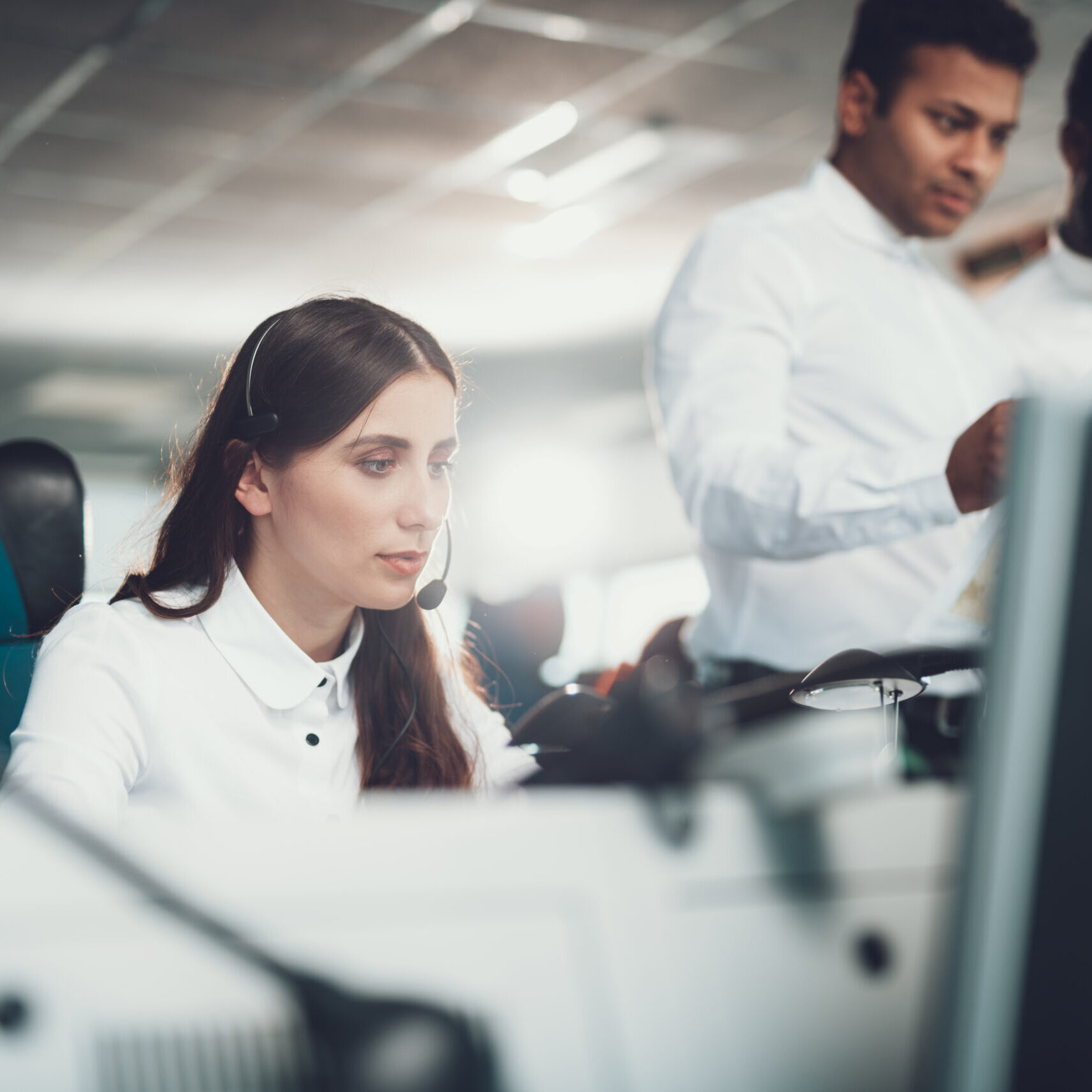 Center of dispatching maintenance. Waist up portrait of operator woman connecting via headset while sitting on navigation controller board